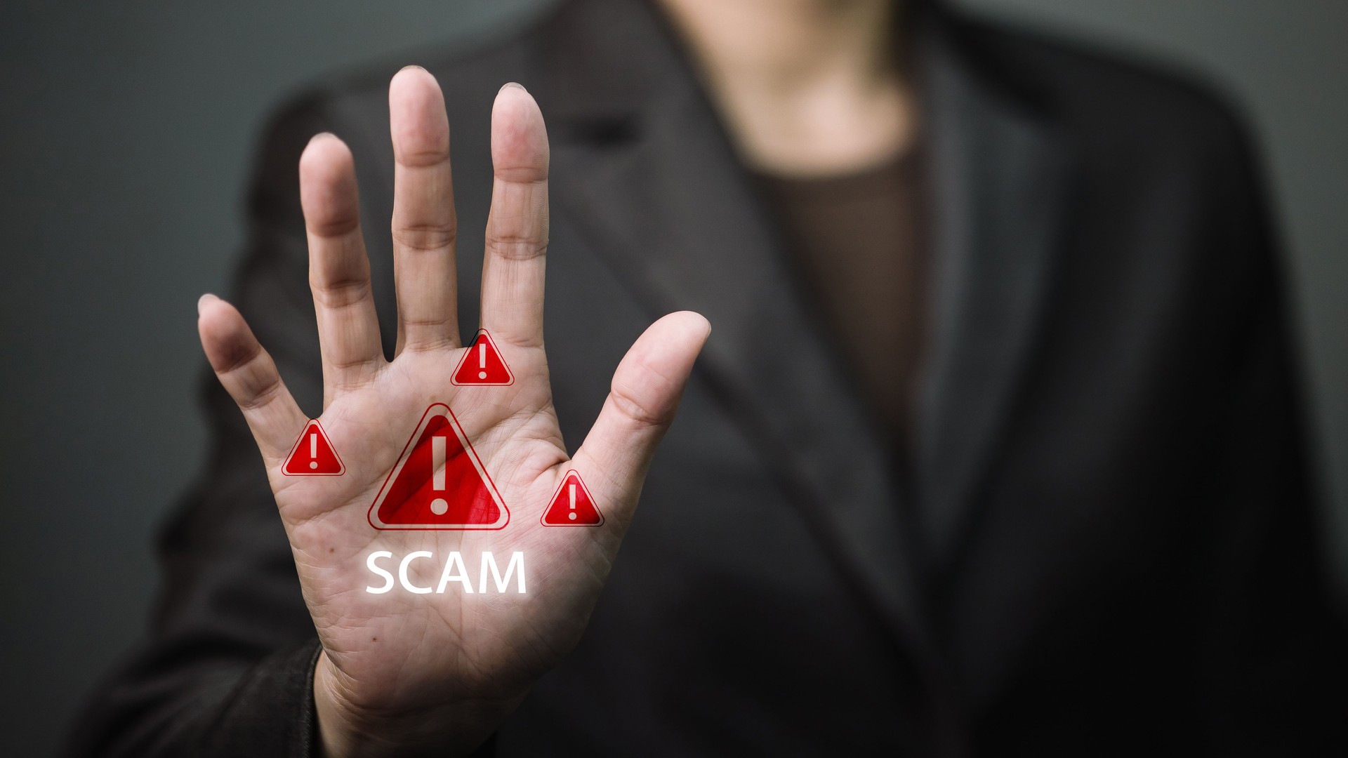 Stop scam warning with red alert icons on businessman hand, fraud prevention and cybersecurity concept