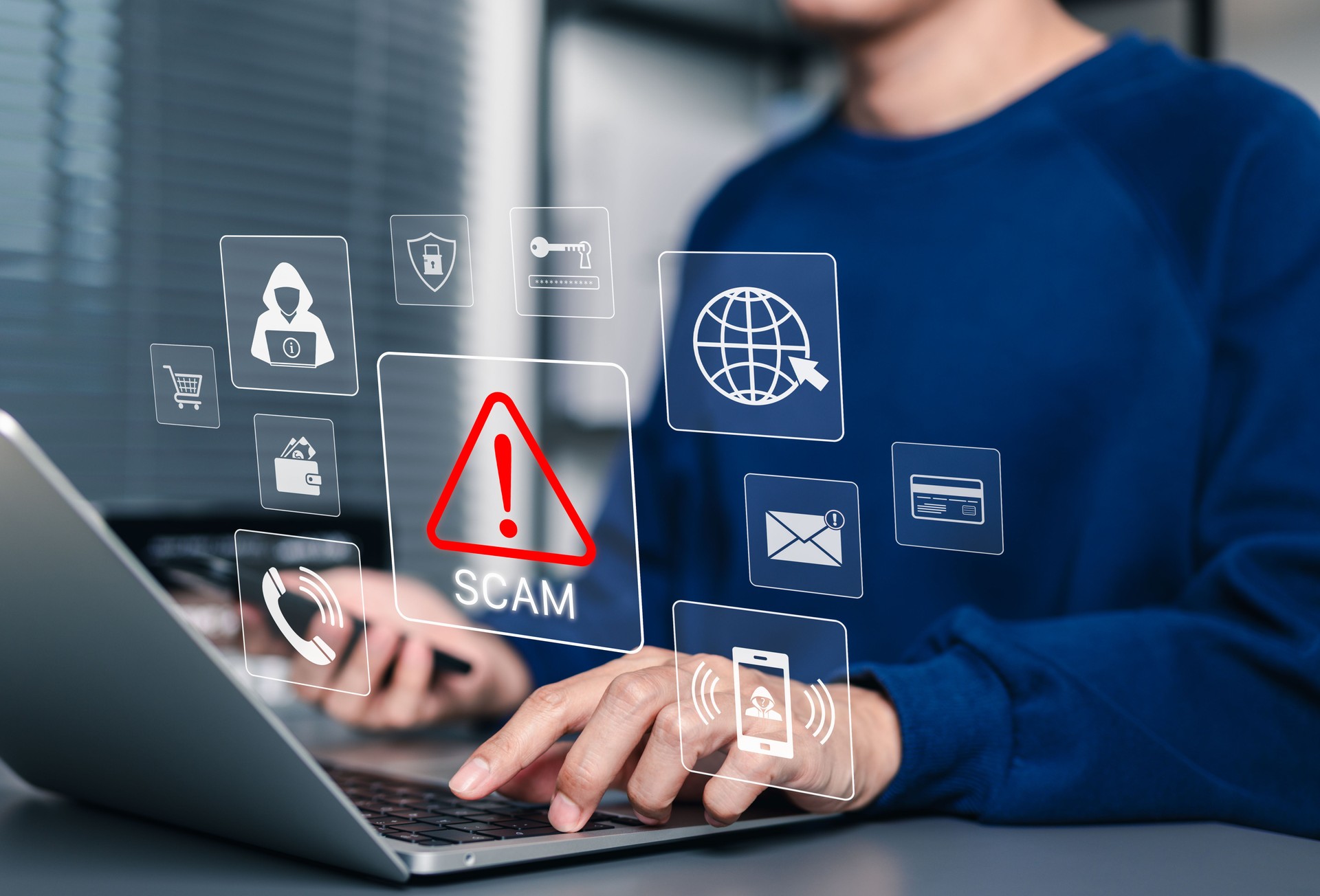 Scam Alert Warning with Cybersecurity Icons. Man holding smartphone while using laptop, warning sign for scams with icons online threats, phishing, cybersecurity, Unknown person, suspicious scammer,